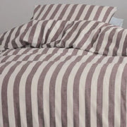 closer view: Close-up of Elias cream and burgundy striped flannel duvet cover folded back beneath matching pillows